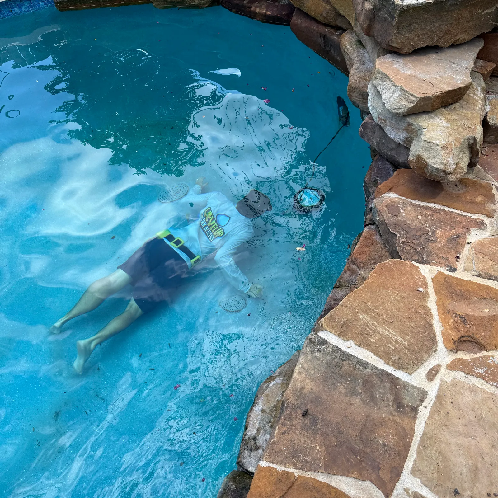 Level Up Leak Detection certified specialist submerged in a pool inspecting the main drain
